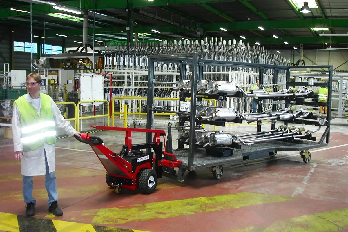 Power Pusher lenken großer 1.100 kg Karren, die mit Abgassystemen für Kraftfahrzeuge beladen sind, und ersetzen manuelle Arbeit bei Faurecia